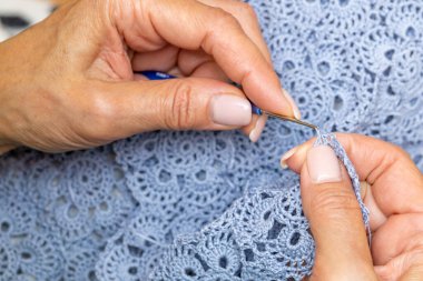 Yün ipliği kullanarak telli el yapımı giysiler ören tanınmamış bir kadının ellerine yakın durun. Boş zaman etkinliği kavramı. İplikten örgü örmek..