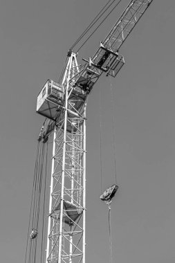 İnşaat halindeki yüksek bina, iskeleli vinç, bir inşaat alanında Freestanding kulesi. Mavi gökyüzüne karşı inşaat alanı çalışması.