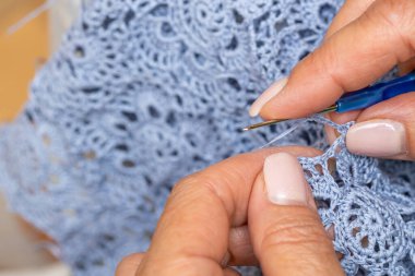 Yün ipliği kullanarak telli el yapımı giysiler ören tanınmamış bir kadının ellerine yakın durun. Boş zaman etkinliği kavramı. İplikten örgü örmek..