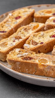 İtalyan bademli bisküvileri kırsal bir evde yapılmış çömlek kasesinde. Badem ve yaban mersiniyle süslenmiş bu iki kez pişirilmiş ikramlar aromatik ve davetkar. İdeal.