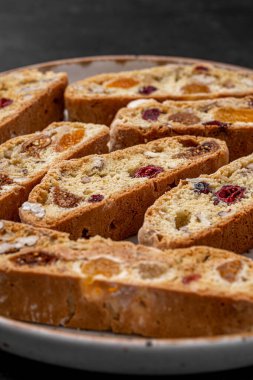 İtalyan bademli bisküvileri kırsal bir evde yapılmış çömlek kasesinde. Badem ve yaban mersiniyle süslenmiş bu iki kez pişirilmiş ikramlar aromatik ve davetkar. İdeal.