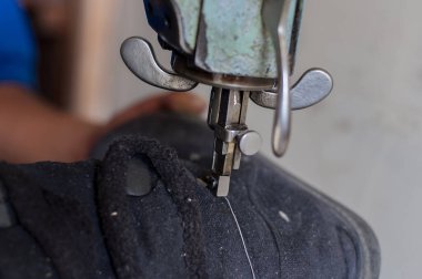 detail shot of a boot at the moment the shoemaker passes the thread to sew the boot.jpg