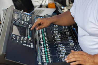 hands of a man manipulating a mixing console