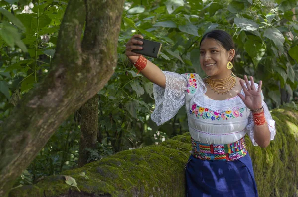 Young native woman posing in the jungle with her smartphone