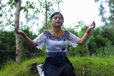 Doğanın ortasındaki bir ayini geleneksel elbisesiyle kutlayan yerli bir kız. Yüksek kalite fotoğraf