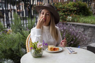 Şapkalı güzel sarışın kadın Focaccia 'nın tadını çıkarıyor. Yüksek kalite fotoğraf