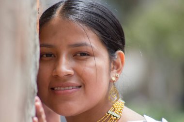 Kafası duvara yaslanmış güzel ve gülümseyen yerli kızın yakın çekimi. Yüksek kalite fotoğraf