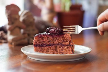 Demir çatal, kafeterya masasında bir tabak yaban mersinli kek kesmek üzere. Yüksek kalite fotoğraf