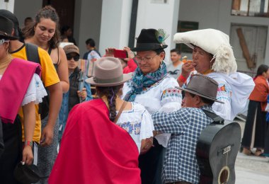 Otavalo, Ekvador - 24 de junio de 2023: Inti Raymi 'deki yerli insanlar aileleriyle yemek yiyorlar. Yüksek kalite fotoğraf