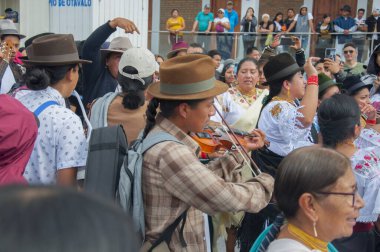 Otavalo, Ekvador - 24 de junio de 2023: otavalo 'lu yerli bir kadın otavalo ekvatorun inti raymisinin geleneksel bir geçidinde keman çalıyor. Yüksek kalite fotoğraf