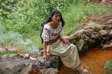 shaman woman preparing a bowl with herbs, sticks and fire for an ancestral rite from ecuador. High quality photo clipart