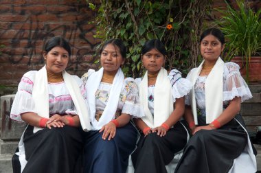 Yerel bir kabileden gelen bir grup genç, parktaki bankta geleneksel giysiler içinde oturuyorlar. Yüksek kalite fotoğraf