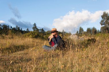 Beyaz kadın bir yaz öğleden sonra dağlarda yürüdükten sonra And flütü çalıyor. Yüksek kalite fotoğraf