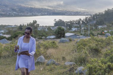 İş kadını güneş gözlüğü takıyor, dağda yürürken kitap okuyor. Yüksek kalite fotoğraf