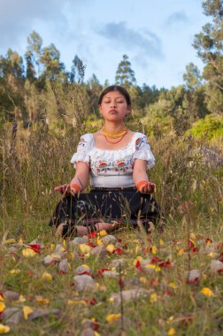 Ottavalo 'da bir parkta meditasyon yapan yerli bir kızın kopyasıyla dikey fotoğraf. Yüksek kalite fotoğraf