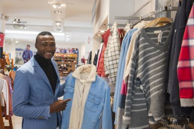 Alışveriş merkezinde ceketli, kameraya gülümseyen mutlu bir zencinin kopyası. Yüksek kalite fotoğraf