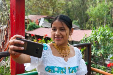 Gülme günü. Ekvador ormanında cep telefonuyla selfie çeken yerli bir kadın. Yüksek kalite fotoğraf