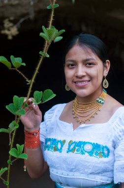 Genç yerli adam dikenli bir dalı tutarken kameraya gülümsüyor. Gülümse günü. Yüksek kalite fotoğraf