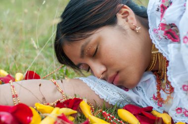 Gül yapraklarıyla çevrili kolunda uyuyan yerli bir kız. Hispanik Miras Ayı. Yüksek kalite fotoğraf
