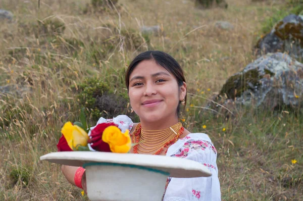 native woman from ecuador offering a hat full of roses looking at camera with a smile.hispanic heritage month. High quality photo