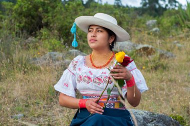 Yerli bir kadın, Christopher Colon 'un ona hoş geldin demek için gül vermesini bekliyor. İspanyol mirası ayı ayı. Yüksek kalite fotoğraf