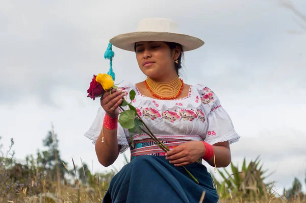 Ottavalo 'dan geleneksel yerli elbisesiyle yerli bir kadın, ekvatorlu. İki gül bakıyor. İspanyol mirası ayı ayı. Yüksek kalite fotoğraf