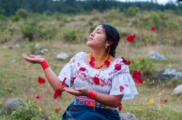 indigenous woman from ecuador receiving a shower of red rose petals in an ancestral ritual. hispanic heritage month. High quality photo