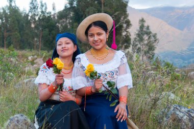 Dağlarda iki İspanyol kardeş geleneksel yerli elbiseli sarı ve kırmızı güller topluyor. İspanyol mirası ayı. Yüksek kalite fotoğraf