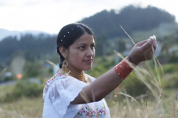 indigenous woman in South America working the agriculture of her native village in Ecuador surrounded by green landscapes following family tradition. Hispanic Heritage Month. High quality photo