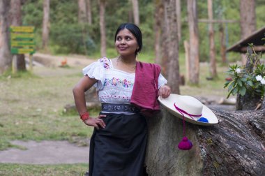 Doğanın ortasında bir dinlenme anında geleneksel elbisesiyle bir bagajın yanında duran yerli bir kadın. Dünya günü. Yüksek kalite fotoğraf