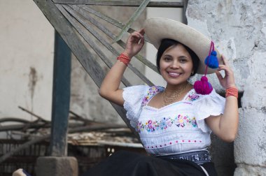 Ekvador 'dan genç, yerli bir kadın elinde geleneksel şapkasıyla kameraya bakarken gülümsüyor ve mutlu görünüyor. Dünya günü. Yüksek kalite fotoğraf