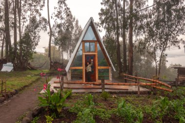 Genç afro kız, organik sebze bahçesiyle çevrili kırsal bir ortamda cazibesine kapılmadan önce kameraya el sallıyor. Turizm günü. Yüksek kalite fotoğraf