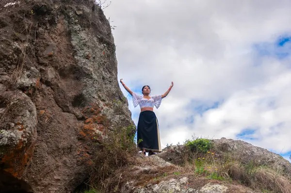 copyspace of panoramic landscape of ecuador with two big rocks where an indian woman imbues mother nature under the white clouds. earth day. High quality photo