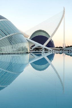 Sanat ve bilim şehrinin fütüristik binaları günbatımında bir gölün durgun sularına yansıyarak Valencia, İspanya 'da çarpıcı bir manzara yaratıyor.