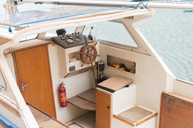 Ahşap direksiyon, torpido, yangın söndürücü ve deniz ekipmanlarını gösteren küçük bir eski kulübe kruvazörü eğlence amaçlı bir tekne yaşam tarzına göz atma olanağı sağlıyor.