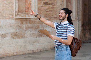 Genç turist, Avrupa 'nın hareketli bir şehrini sevinçle keşfediyor, elinde bir haritayla, kültürel bir yolculukta tek başına seyahat etmenin ruhunu somutlaştırıyor.
