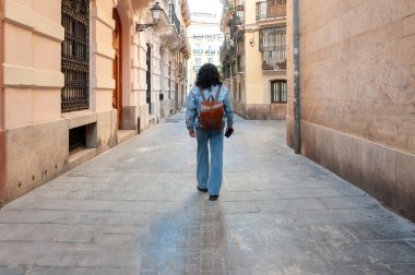 Sırt çantalı ve akıllı telefonlu genç bir kadın okul balosunun canlı sokaklarında dolaşır, tek başına seyahat eder özgürlük ve seyahat tutkusu hisseder.