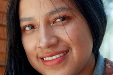 Bu büyüleyici görüntü neşe dolu genç bir kadını sergiliyor, narin bir gülümseme yayarak güzelliğini vurguluyor.