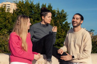 Neşeli ve hareketli bir anda arkadaşlarımız neşeyle gülüyor ve açık havada samimi bir sohbete dalıyorlar.