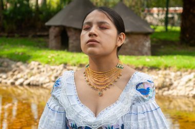 Doğada sakin ve huzurlu bir an yakalanıyor. Geleneksel giysiler ve zarif mücevherler sergileniyor.