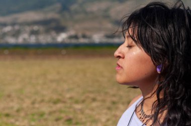 Bir kadın, doğal güzellikler arasında bir iç gözlem anı yakalayarak dışarıda huzuru tecrübe eder..