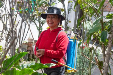 Neşeli ve kendini işine adamış bir bahçıvan canlı, yemyeşil bir bahçede çalışarak doğayla derin bağlantılarını gösteriyor.