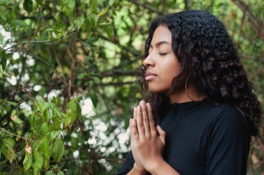 Huzurlu genç bir kadın, yemyeşil, huzur ve farkındalığı somutlaştıran, meditasyonla meşgul olur..