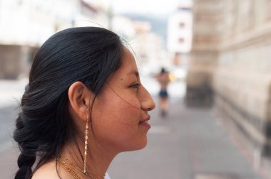 Canlı bir şehir manzarasına karşı geleneksel mücevherlerle süslenmiş genç bir kadının güzel bir profil görüntüsü.