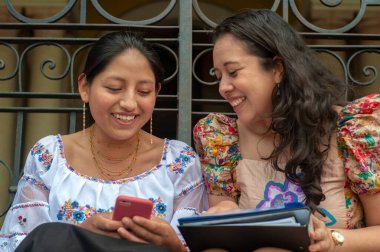 İki neşeli kadın, akıllı telefonlar kullanarak, olağanüstü arkadaşlıklarını sergileyerek, canlı sohbetler yapıyorlar.