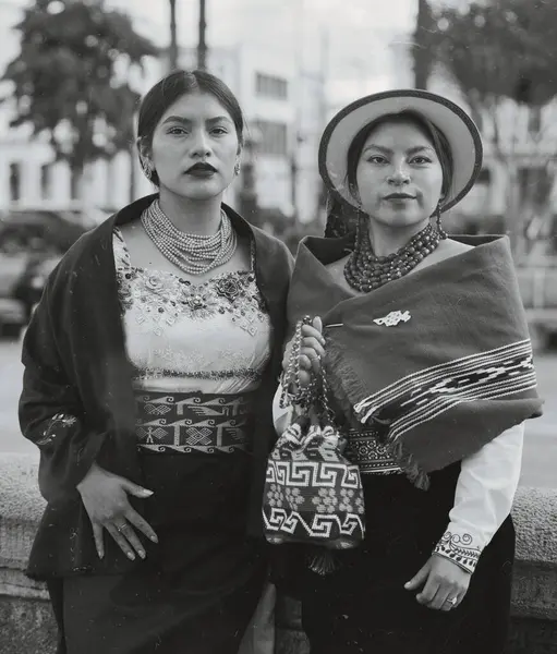 Geleneksel andean giysileri, mücevherler ve aksesuarlar giyen iki yerli kadın, zengin kültürel miraslarını gururla sergiliyorlar.