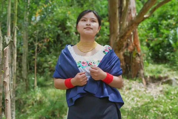 Geleneksel kıyafet ve mücevher giyen yerli Kolombiyalı kadın doğal bir ortamda kültürel mirasını gururla kucaklıyor.
