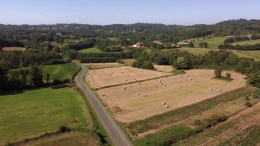 Flight Through Countryside Fields With Roll Hay Bale Near Idyllic Town. Aerial Drone Shot