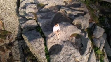Ascending On A Woman Sitting At The Edge Of Rocky Formation At Punta Nariga In Galicia, Malpica de Bergantinos, Spain.