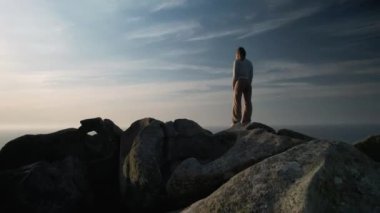 Woman Standing On The Rock Boulders At Punta Nariga In Costa da Morte (Death Coast) In Galicia Malpica, Spain. FPV